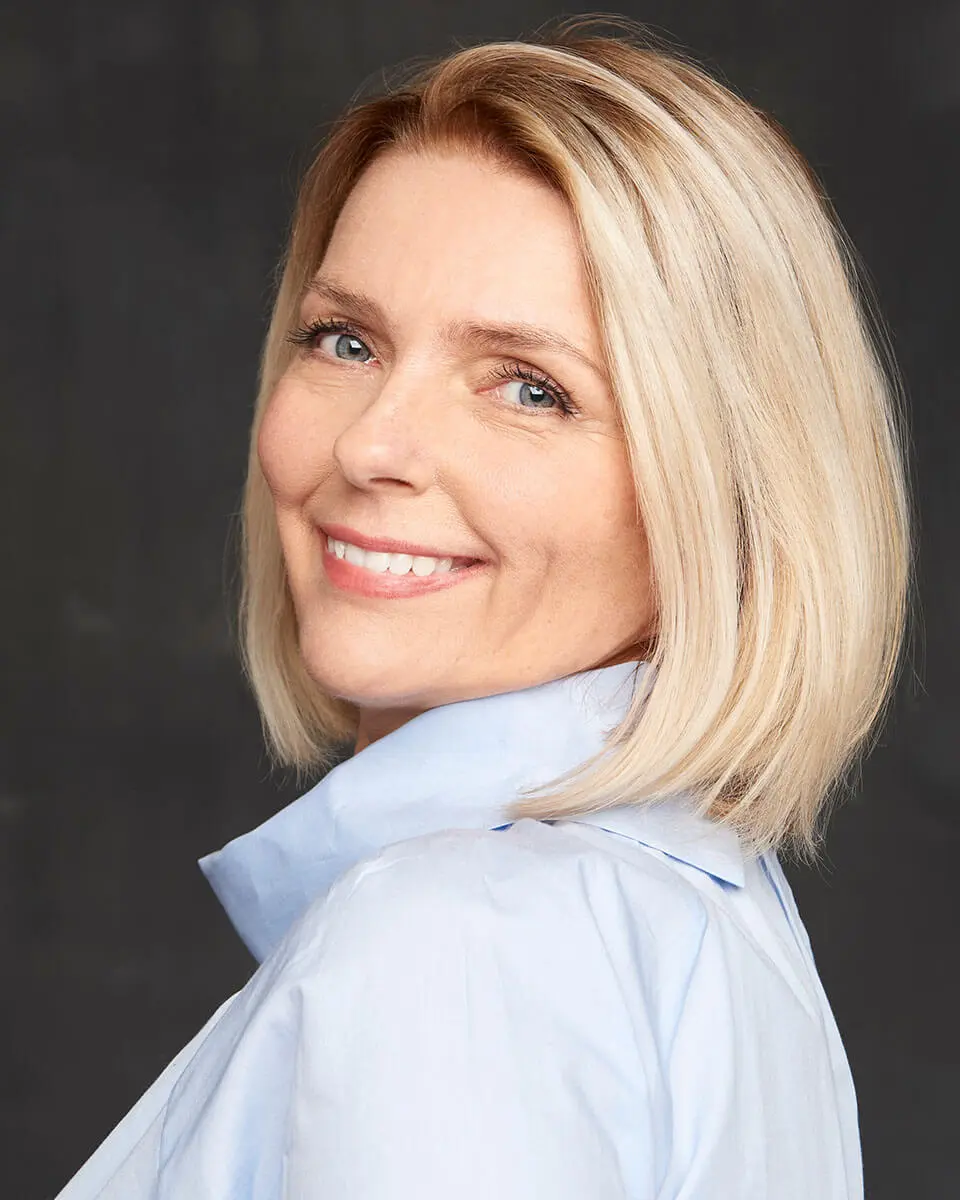 Mature blond woman in a blue button up shirt