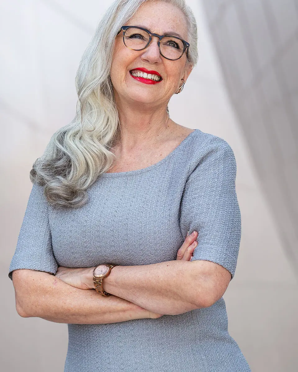 Mature, happy woman with her arms crossed