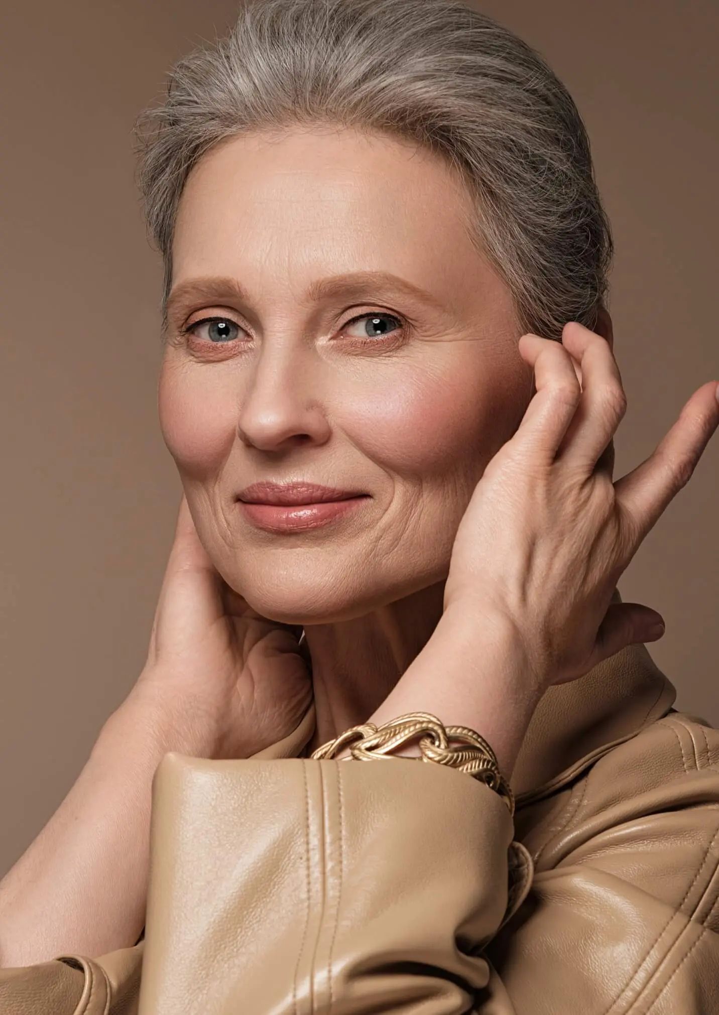 Older woman brushing her hair behind her ear
