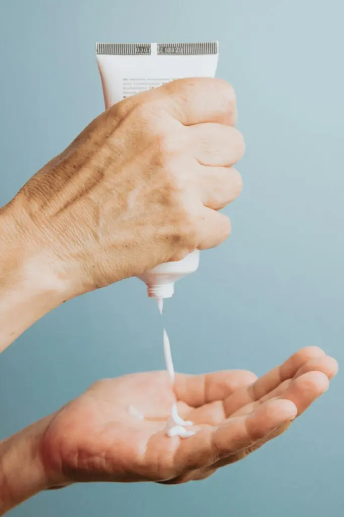 a close up of a pair of hands pouring sunscreen