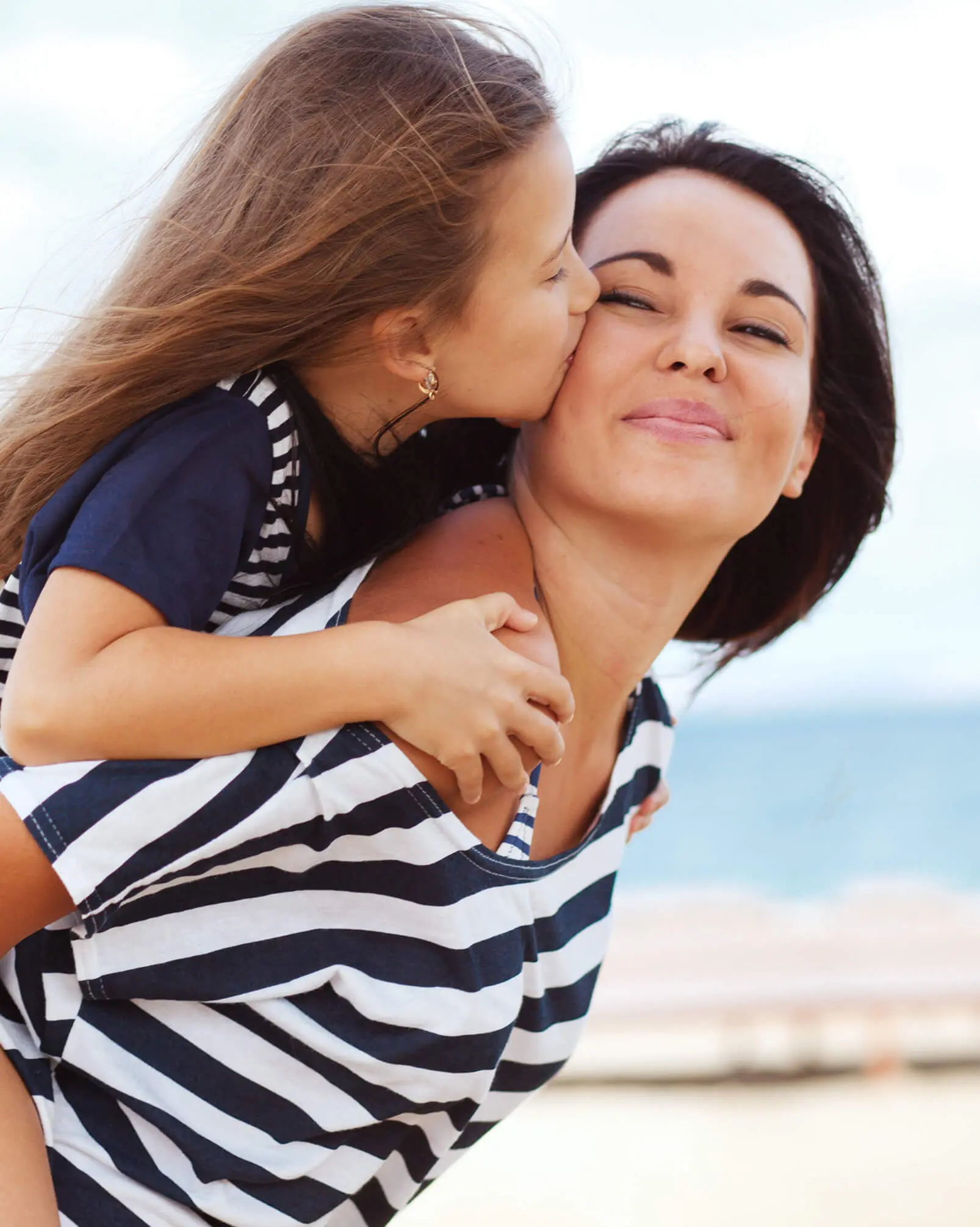 Female child kissing her mom on the cheek