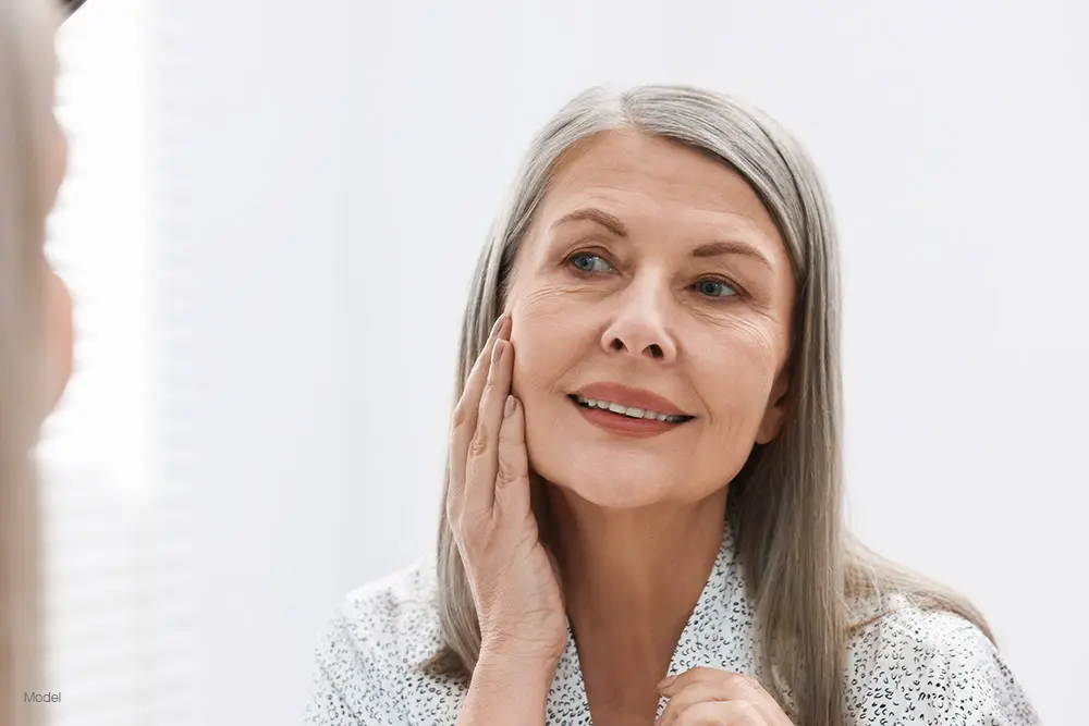 Mature woman looking at herself in the mirror